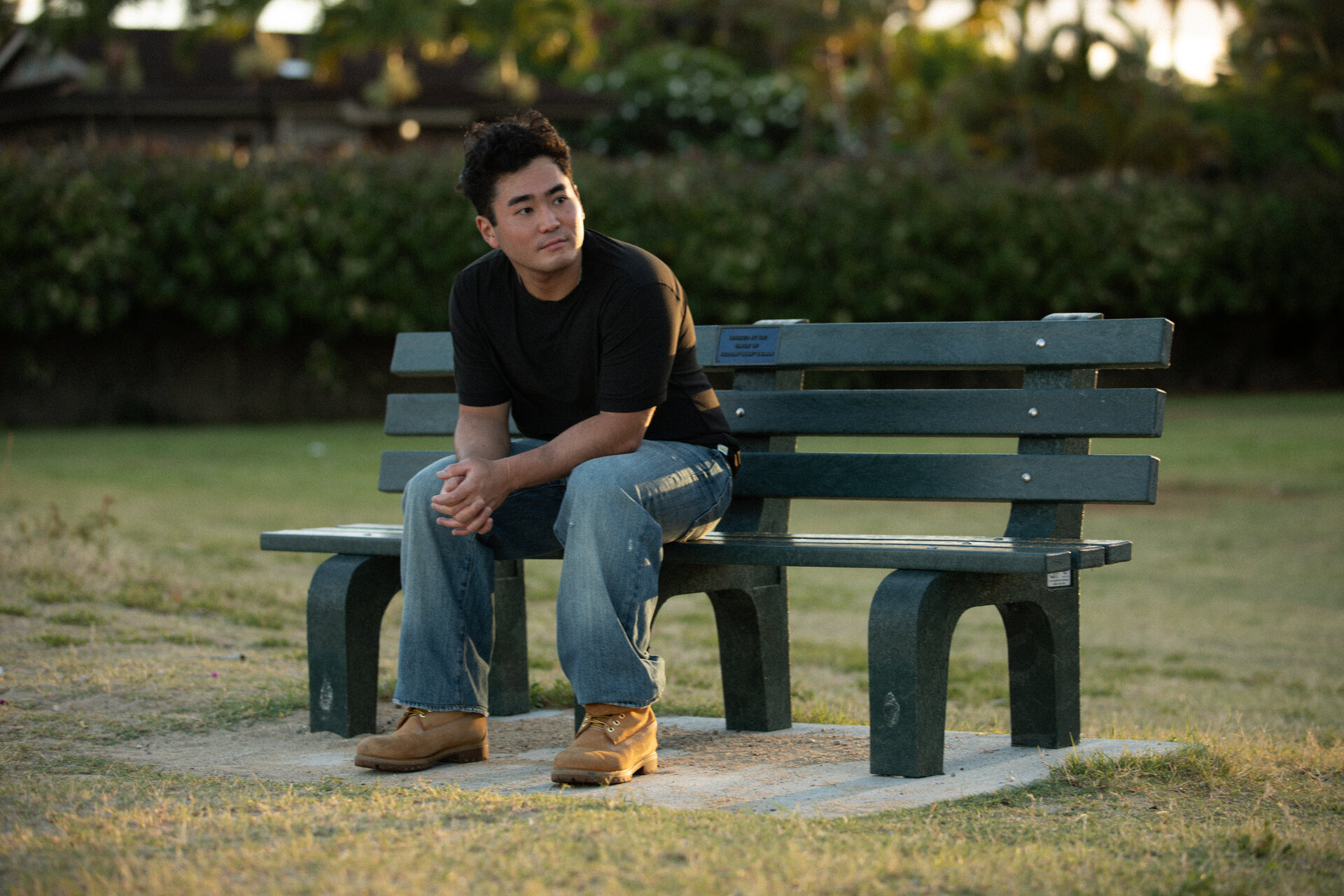 Nick Laʻa seated on a park bench